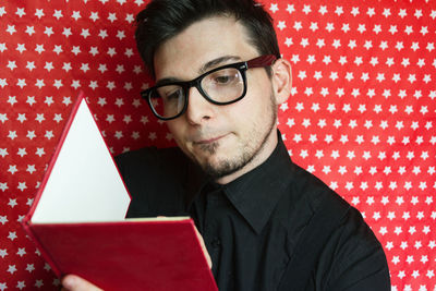 Man wearing eyeglasses while reading book