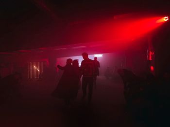 Silhouette people standing in illuminated building at night