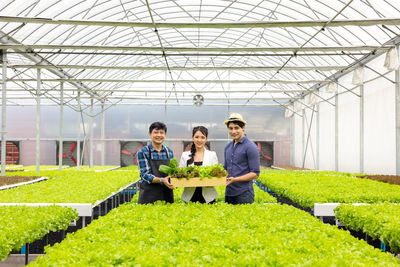 Portrait of woman standing in greenhouse