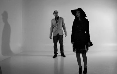 Full length of young couple standing against white background