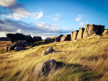 Panoramic view of rocks on field against sky