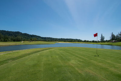 Scenic view of golf course against sky