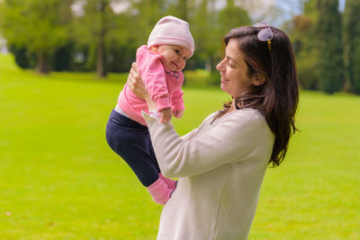 Side view of mother and daughter on grass