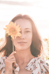 Close-up portrait of woman holding flowering plant