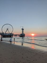 Scenic view of beach against clear sky during sunset