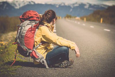 Rear view of people sitting on road