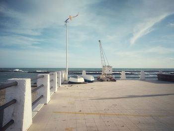 Sailboat on pier by sea against sky