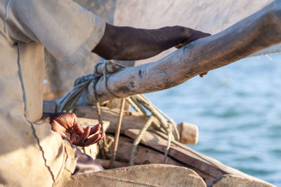 Midsection of man sitting on boat