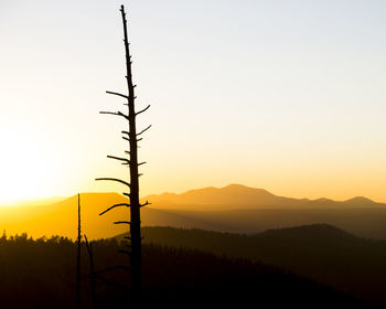 Silhouette landscape against clear sky during sunset