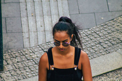 High angle view of woman wearing sunglasses standing outdoors
