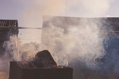 Smoke emitting from chimney against sky