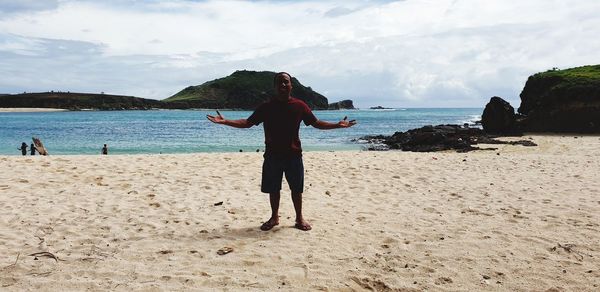 Full length of man standing on beach against sky