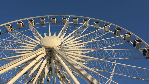 Low angle view of ferris wheel against blue sky