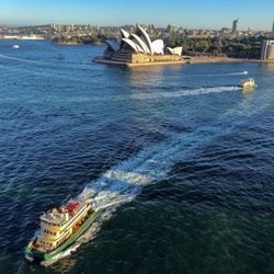 High angle view of ship on sea with buildings in background against sky