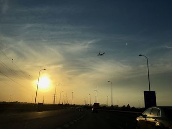 Airplane flying against sky during sunset