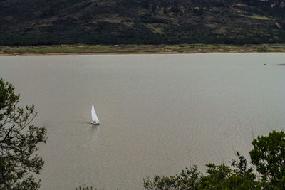 Sailboat on lake against mountain