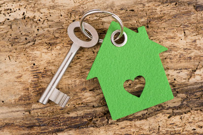 Close-up of house key with model home on wooden table