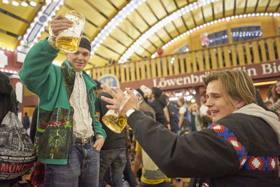 Friends drinking beer at illuminated amusement park