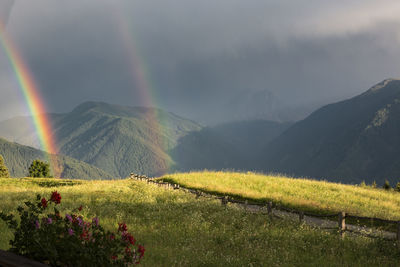 Scenic view of rainbow over mountain against sky