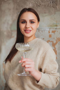 Portrait of smiling young woman drinking glass