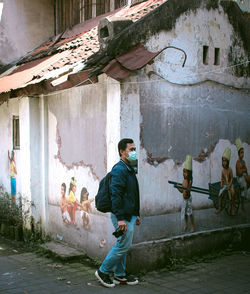 Full length of man standing against wall