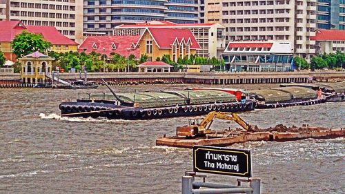 Boats in river with buildings in background