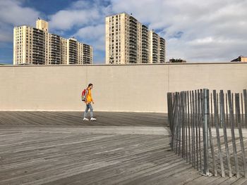 Full length of man running against building in city