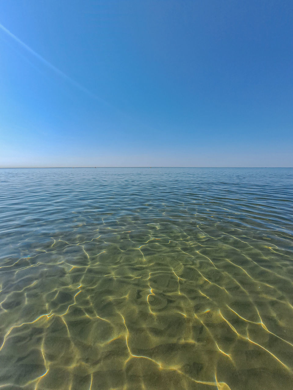 horizon, sky, water, sea, blue, ocean, beauty in nature, scenics - nature, nature, tranquility, clear sky, natural environment, land, horizon over water, tranquil scene, no people, day, shore, idyllic, rippled, copy space, outdoors, sand, coast, sunlight, pattern, wave, environment, beach, landscape, wave pattern, urban skyline, body of water, backgrounds, sunny