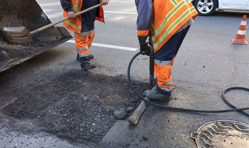 Low section of workers constructing on road in city