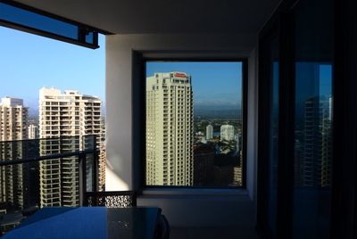 Modern office buildings against blue sky seen through window