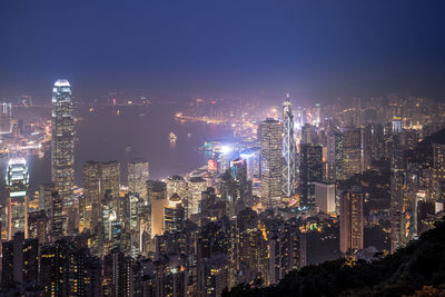 Illuminated cityscape against sky at night