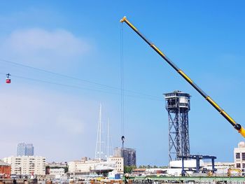 Low angle view of cranes against blue sky