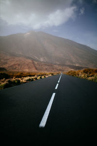 Empty road against mountain range