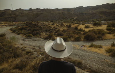 Rear view of adult man in cowboy hat in desert. almeria, spain