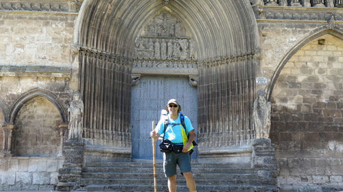 Full length of a pilgrim standing on staircase against building