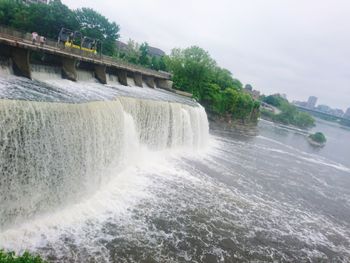 Scenic view of waterfall against sky