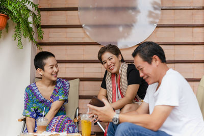 Friends having a great time smiling and drinking coffee and juice in cafe.