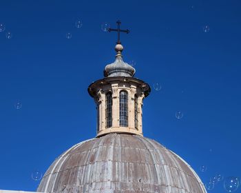 Low angle view of bell tower against blue sky