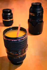 Close-up of juice served in camera lens on table