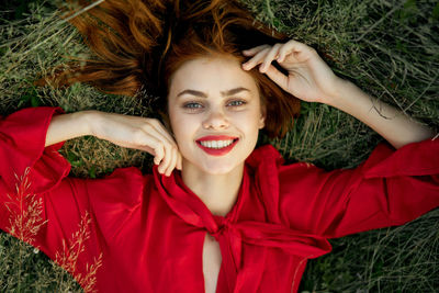 Portrait of a smiling young woman lying in grass