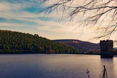 Scenic view of river by mountains against sky