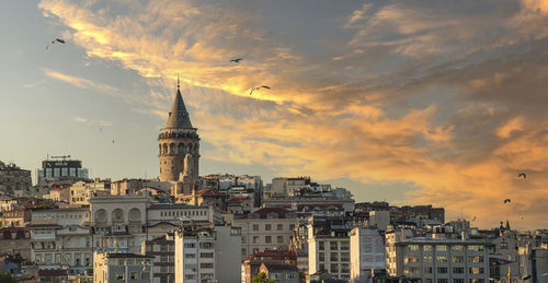 Buildings in city against sky during sunset