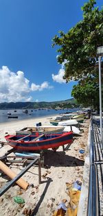 Boats moored on beach against sky