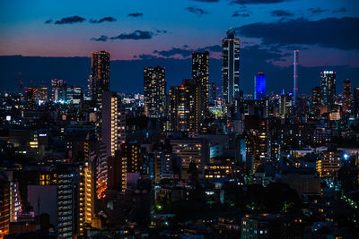 Illuminated cityscape against sky at night