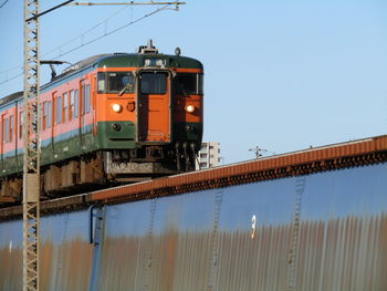 Train on railroad track against clear sky