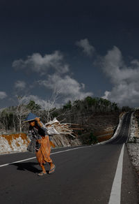 Full length of woman walking on road against sky