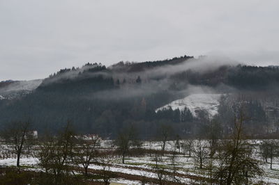 Scenic view of snow covered land against sky