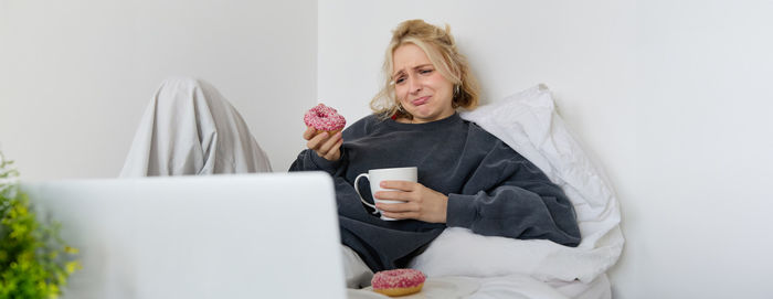 Portrait of young woman using laptop at home