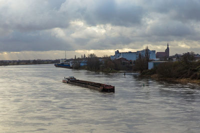 Nautical vessel on river against sky in city