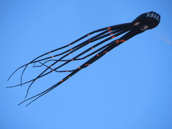 Low angle view of kite against clear blue sky